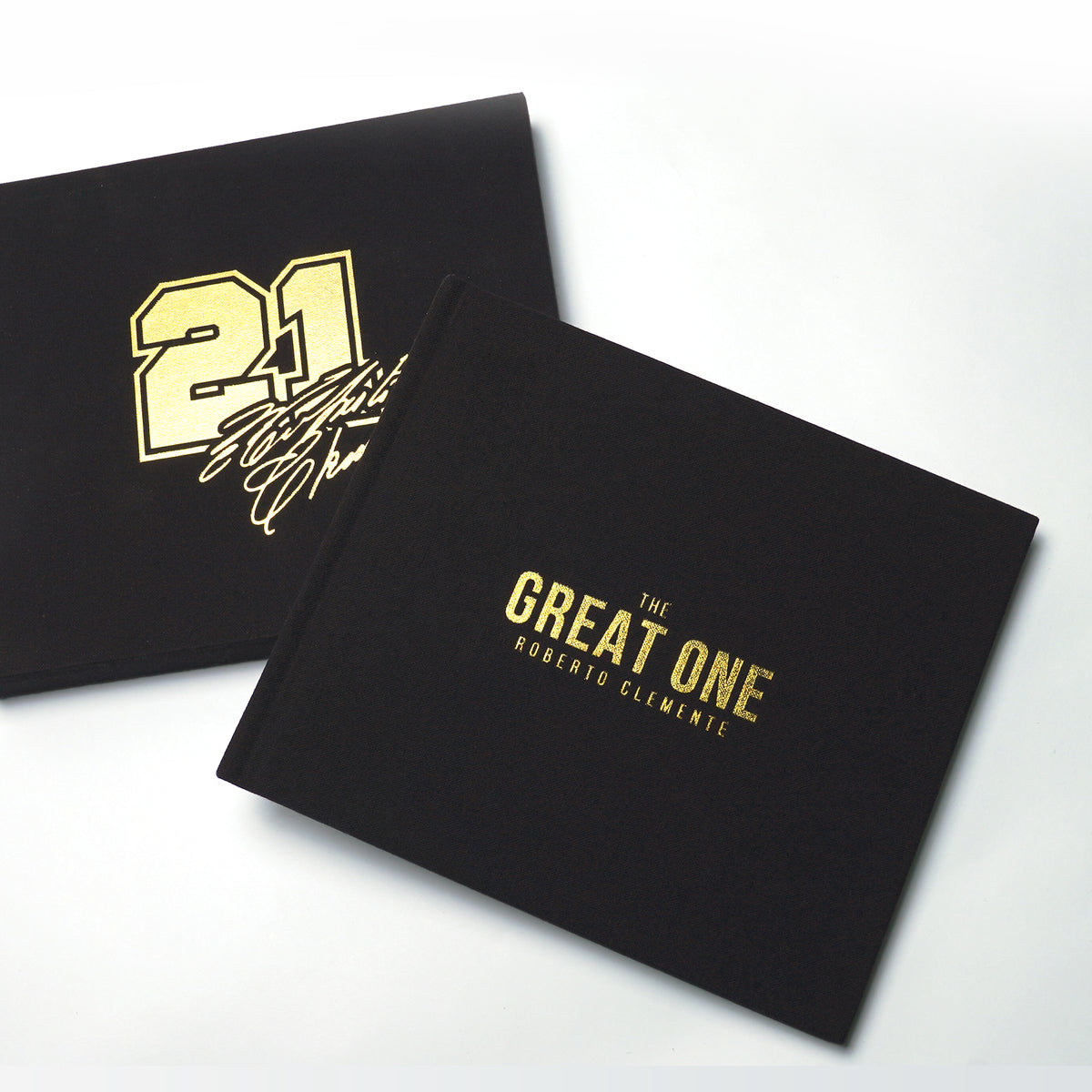 The Great One Roberto Clemente book with black cloth cover and gold foil title beside a gold foil number 21 sleeve
